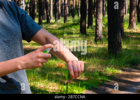 Mädchen im Wald sprüht gegen Mücken Stockfoto