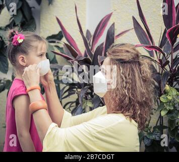 Frau und Tochter tragen eine Einwegmaske, um Virusinfektionen zu vermeiden. Schutz vor Coronavirus Stockfoto