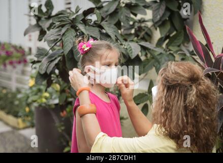 Frau und Tochter tragen eine Einwegmaske, um Virusinfektionen zu vermeiden. Schutz vor Coronavirus Stockfoto