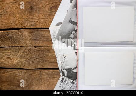 Fotoalbum und alte Schwarzweißfotos auf Holzhintergrund und Platz für Text Stockfoto