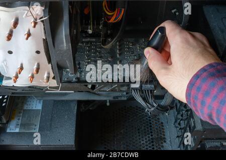 Der Mensch reinigt einen Computer vor Staubablagerungen Stockfoto