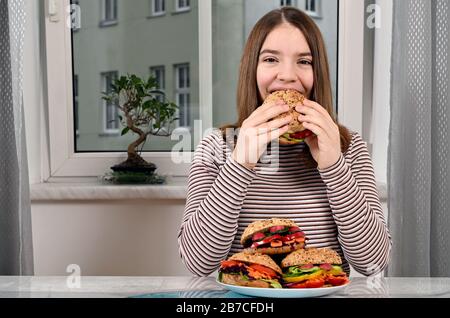 Hungriges Mädchen, das veganes Sandwich isst Stockfoto