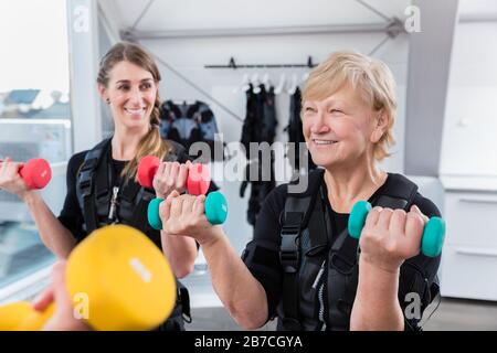 Senior und junge Frau während des ems-Trainings Stockfoto