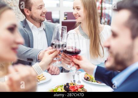 Fröhliche Leute genießen Getränke und Essen im italienischen Restaurant Stockfoto