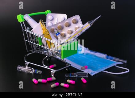 Mpoules, Thermometer, medizinische Maske auf schwarzem Hintergrund. Konzept zum Schutz vor Viruserkrankungen, Quarantäne. Stockfoto