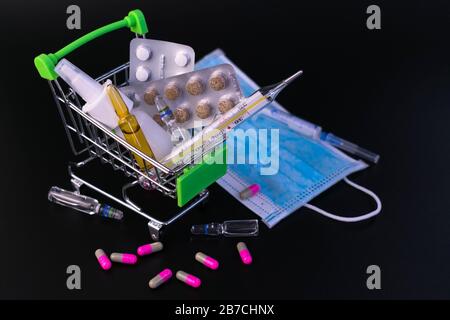 Mpoules, Thermometer, medizinische Maske auf schwarzem Hintergrund. Konzept zum Schutz vor Viruserkrankungen, Quarantäne. Stockfoto