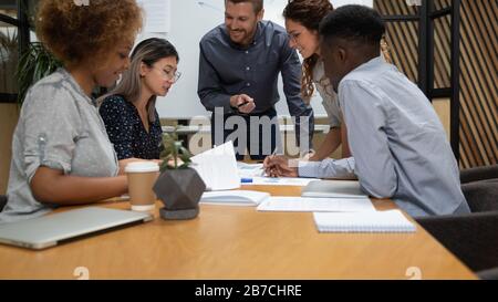 Team verschiedener Mitarbeiter arbeitet bei der Besprechung mit Dokumenten, Projektstatistiken Stockfoto