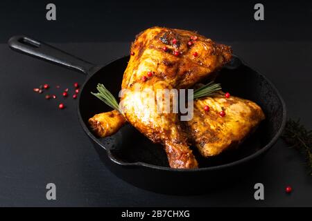 Lebensmittelkonzept Bio geröstete oder gegrillte Hühnerbeinflegerquartiere in Skillet-Eisenpfanne auf schwarzem Schiefersteinplatte Stockfoto