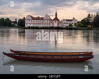 SCHARDING, ÖSTERREICH - JULY12, 2019: Blick über den Inn zum Schloss Neuhaus am Inn mit Holzbooten im Vordergrund Stockfoto