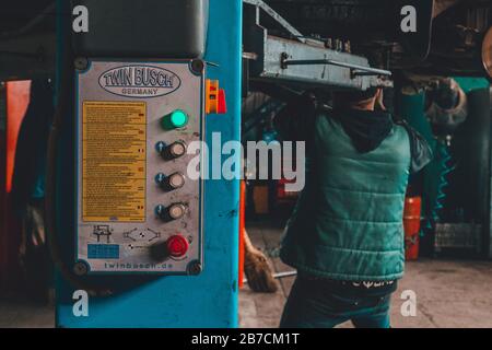 Lemberg, Ukraine - 03. März 2020: Der Mechaniker hob das Auto mit einem Aufzug an, um den Motor 2020 zu warten Stockfoto