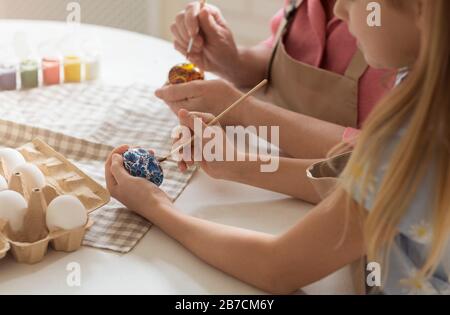 Kleines Kind mit Oma, das Eier für Ostern malt, Nahaufnahme Stockfoto