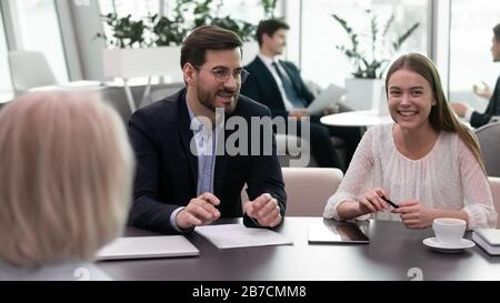 Lächelnde Geschäftsleute führen ein Brainstorming durch, bei dem sie über das Projekt bei der Besprechung diskutieren Stockfoto