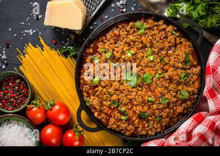 Bolognese steht in Eisenplatte am schwarzen Tisch. Stockfoto