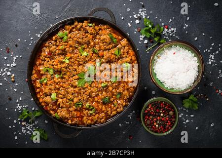 Bolognese steht in Eisenplatte am schwarzen Tisch. Stockfoto