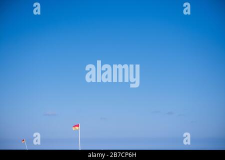 Rot über gelber Flagge, was auf einen sicheren Platz zum Schwimmen unter Aufsicht hinweist Stockfoto