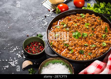 Bolognese steht in Eisenplatte am schwarzen Tisch. Stockfoto