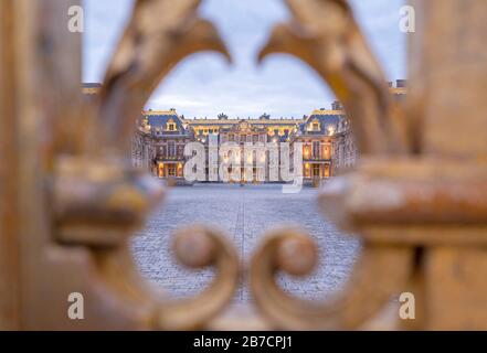 Die Ostfassade des Schlosses Versailles sah durch die vergoldeten Balken des Eingangstors, Frankreich Stockfoto