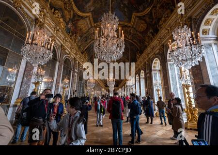 Touristen, die den Spiegelsaal im Schloss Versailles am Stadtrand von Paris, Frankreich, Europa besuchen Stockfoto