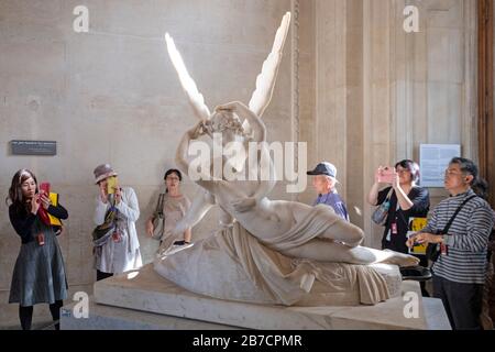 Asiatische Touristen, die die Psyche fotografieren, die von Cupid's Kiss des italienischen Künstlers Antonio Canova im Louvre in Paris, Frankreich, Europa wiederbelebt wurde Stockfoto
