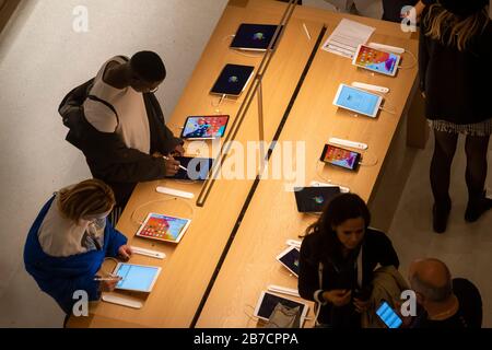 Kunden, die Apple Produkte im Apple Store auf der Champs-Elyssees Avenue in Paris, Frankreich, Europa, durchsuchen Stockfoto