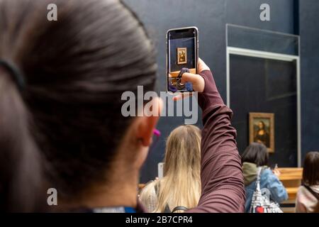 Tourist, die mit ihrem Smartphone Bilder des Mona-Lisa-Gemäldes der Künstlerin Leonardo da Vinci, Louvre Museum, Paris, Frankreich, Europa fotografiert Stockfoto