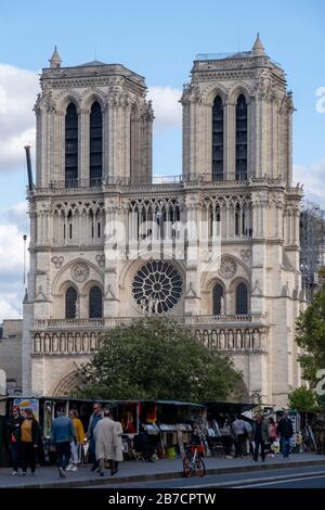 Menschen, die an Buchhändlerbuden entlang der seine mit der Kathedrale Notre Dame im Hintergrund vorbeiziehen, Paris, Frankreich, Europa Stockfoto