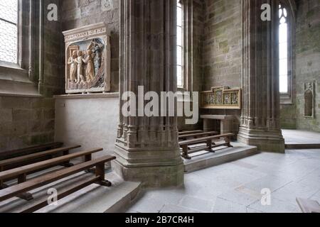 Kirchenbänke und religiöse Kunst im Inneren der Abtei am Mont Saint-Michel, Normandie, Frankreich, Europa Stockfoto