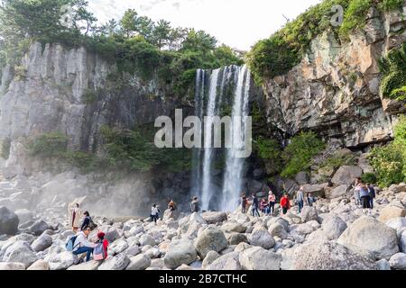 SEOGWIPO, JEJU-INSEL, SÜDKOREA - 3. NOVEMBER 2018. Eine Gruppe von Menschen nimmt Bilder in der Waterfall Attraction auf. Stockfoto