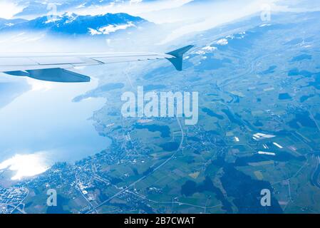 Einzigartiges alpines Luftpanorama. Blauer Planet Erde Höhenflug von einem Flugkabinenfenster aus, das über Zürich fliegt, aus dem Blick auf die Schweizer Alpen Stockfoto