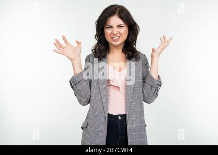 Empörtes wütendes Mädchen in einer grauen Jacke auf weißem Hintergrund Stockfoto