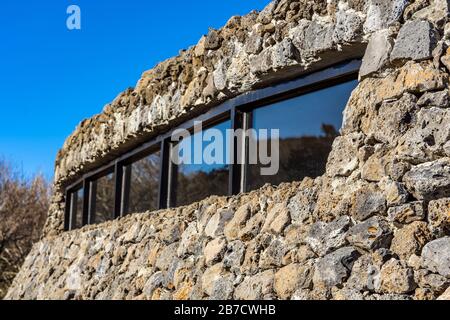 Geschlossen mit moderner öffentlicher Architektur. Gebogene schräge Wand aus Stein. The Rock Shed. Stockfoto