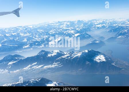 Einzigartiges alpines Luftpanorama. Blauer Planet Erde Höhenflug von einem Flugkabinenfenster aus, das über Zürich fliegt, aus dem Blick auf die Schweizer Alpen Stockfoto