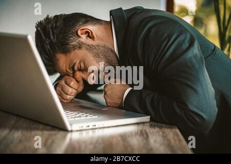 Müde Business Man Schläft Im Notebook Stockfoto