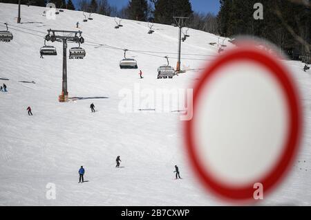 Feldberg Im Schwarzwald. März 2020. Skifahrer und Snowboarder fahren auf der Piste bei Seebuck auf dem Feldberg im Schwarzwald vor einem Verbotsschild. Wegen des Corona-Virus hat der Liftbetreiber beschlossen, die Lifte ab 16.03.2020 zu schließen. Credit: Patrick Seeger / dpa / Alamy Live News Stockfoto
