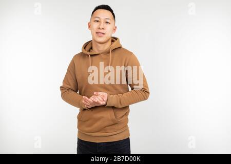 Selbstbewusster asiat Mann im braunen Hoodie isoliert auf weißem Hintergrund Stockfoto