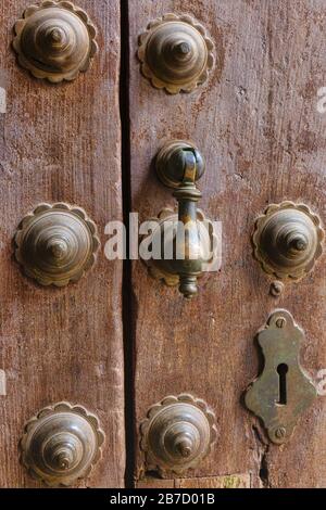 Schlüsselloch, Metallbolzen und Türklopfer an der alten Holztür. Cordoba, Provinz Cordoba, Andalusien, Südspanien. Das historische Zentrum von Cordoba i. Stockfoto