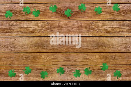 Auf dem alten Holzhintergrund blättert Papierklee. Lucky Shamrock, St. Patrick's Day Feriensymbol. Platz für Text, Draufsicht. Stockfoto