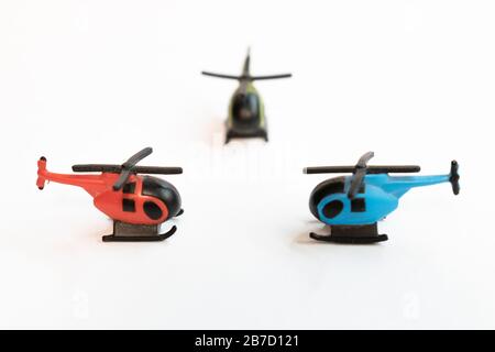 Kleine bunte Helikopter-Spielzeuge isoliert auf weißem Hintergrund - Flugreisen per Hubschrauberkonzept. Stockfoto