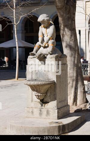 Girona, Spanien - 24. Februar 2020: Denkmal "Junge und Schildkröte" auf dem Unabhängigkeitsplatz mit Bändern mit Flagge Kataloniens. Der katalanische Unabhängigkeitszug Stockfoto