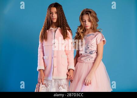 Zwei schöne modische Mädchen in modischen pinkfarbenen Kleidern Stockfoto