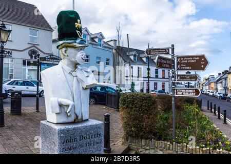 Ardara, County Donegal, Irland. März 2020. Die Büste des berühmten irischen Geige Spieler, John Doherty, ist mit Maske und Hut verspottet die aktuelle Coronavirus, Covid-19, Pandemie geschmückt. Die St. Patrick's Day Parade der Stadt wurde zusammen mit den meisten solchen Paraden in Irland abgesagt. Stockfoto