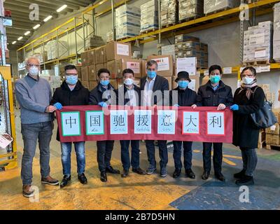 Turin, Italien. März 2020. Der chinesische Generalkonsul in Mailand Song Xuefeng (4. L) und Luigi Genesio Icardi (4. R), Stadtrat für Gesundheit der Region Piemont, posieren für ein Foto in Turin, Italien, 14. März 2020. Etwa 26,4 Tonnen medizinisches Material, das von der ostchinesischen Provinz Zhejiang aufgebracht wurde, sind nach Angaben des chinesischen Generalanwalts in Mailand in der norditalienischen Stadt Turin angekommen. Kredit: Xinhua/Alamy Live News Stockfoto