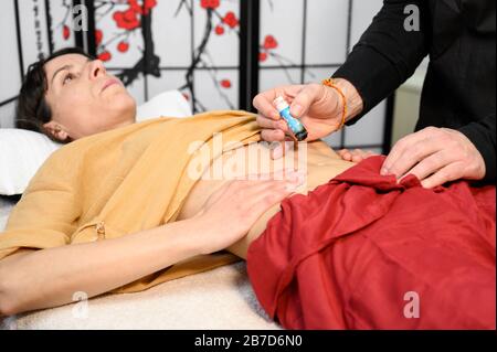 Alternative Therapeutin, die Moxibustion eine traditionelle chinesische Medizinmethode anwendet. Stockfoto