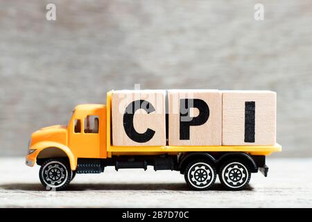 LKW hält Buchstabenblock im Wort CPI (Abkürzung des Verbraucherpreisindex) auf Holzhintergrund Stockfoto