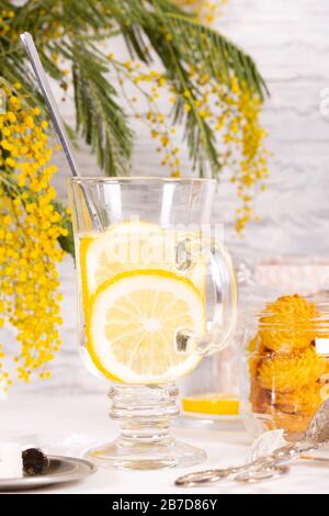 Glas Wasser mit Zitrone auf dem Küchentisch Stockfoto