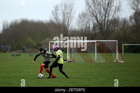 Die Menschen spielen Fußball auf Hackney Marshes in London nach der Ankündigung vom Freitag, dass die Premier League alle Spiele bis zum Samstag, den 4. April 2020 ausgesetzt hat. Stockfoto