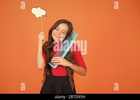 Tipps für gesunde Curl. Beauty und Mode. denken an neue Frisur. Schulmädchen halten großen Kammaufsatz. Pflege und bürsten Sie Ihr Haar. Kleines Mädchen lange Haare. Kind mit lockigem Haar. Friseur für Kid. Stockfoto