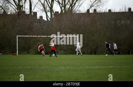 Die Menschen spielen Fußball auf Hackney Marshes in London nach der Ankündigung vom Freitag, dass die Premier League alle Spiele bis zum Samstag, den 4. April 2020 ausgesetzt hat. Stockfoto