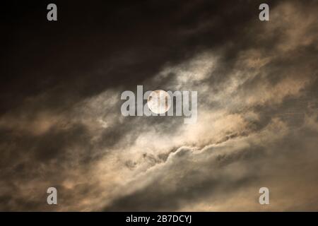 Ein abstraktes Foto der aufgehenden Sonne verdunkelt hinter dramatischen, dunklen, stürmischen Wolken, aufgenommen in der Madikwe Game Reserve, Südafrika. Stockfoto