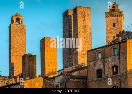 Die mittelalterlichen Türme von San Gimignano, der Toskana, Italien (UNESCO-Weltkulturerbe) dominieren die Skyline der Stadt im Mai bei Sonnenuntergang. Stockfoto